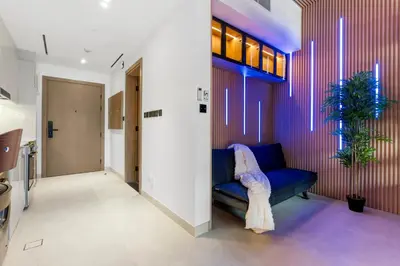 a living room with a blue couch and a hallway at Exclusive Apt 4 Pex with Burj Khalifa View in Dubai