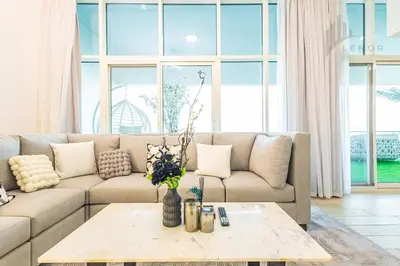 a living room with a couch and a table at Modern 2BR Glowing Palm Trees Near Downtown in Dubai