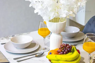 a table with a plate of fruit and glasses of orange juice at Modern 2BR Glowing Palm Trees Near Downtown in Dubai