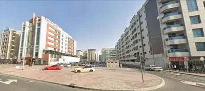 a street with cars parked in a city with tall buildings at Gateway Partition Room in Barsha Mashreq Metro in Dubai