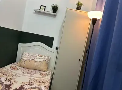 a room with a bed with a pillow and a lamp at Gateway Partition Room in Barsha Mashreq Metro in Dubai