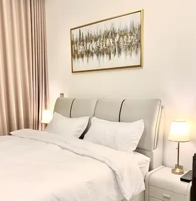 a bedroom with a white bed and a painting on the wall at Azizi Rivera Luxury Studio in Dubai