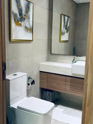 a bathroom with a toilet and a sink and a mirror at Azizi Rivera Luxury Studio in Dubai