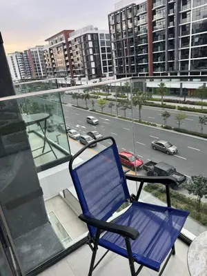 a blue chair sitting on a balcony with a table at Azizi Rivera Luxury Studio in Dubai