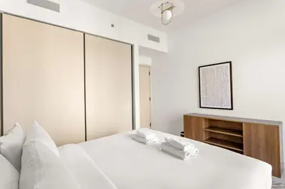 a bedroom with a white bed with two towels on it at Silkhaus Beachside Spacious 2BDR in Marina Vista in Dubai