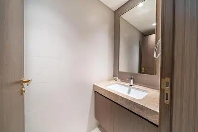 a bathroom with a sink and a mirror at Homes Beyond I Stylish 2BR Beachfront Bliss in Dubai