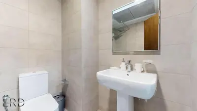a white bathroom with a sink and a toilet at Modern Furnished Studio in Dubai
