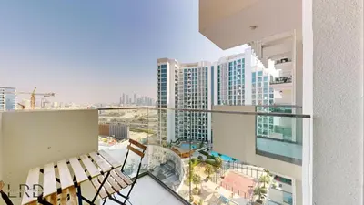 a balcony with chairs and a view of a city at Stylish Studio Retreat in Azizi Farhad in Dubai