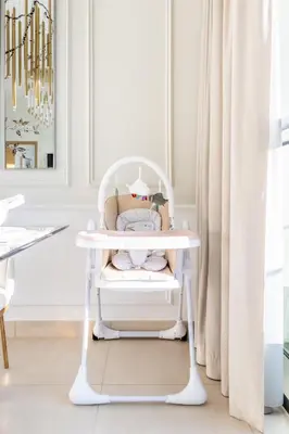 a white high chair in a room with a curtain at Elegant 4BR Apartment with Burj Khalifa and Fountain Views Connected to Dubai Mall in Dubai
