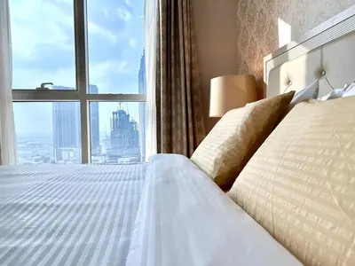 a bedroom with a white bed with a large window at Homes 2 Retreat - Luxury & Spacious 1BR with Balcony in Business Bay in Dubai