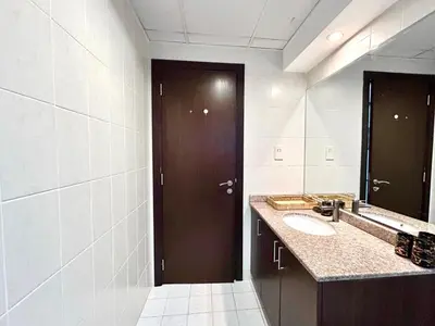 a bathroom with a sink and a brown door at Homes 2 Retreat - Luxury & Spacious 1BR with Balcony in Business Bay in Dubai