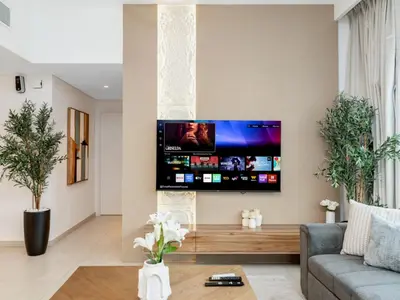 a living room with a flat screen tv on a wall at Royal Vista - Luxury 4BR Apartment at Downtown Views II - Downtown in Dubai