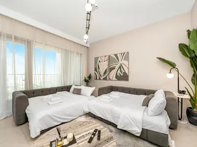 a bedroom with two beds and a couch at Royal Vista - Luxury 4BR Apartment at Downtown Views II - Downtown in Dubai
