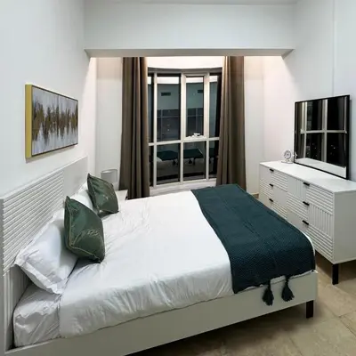 a bedroom with a bed and a dresser and a television at Preatoni Tower - JLT by Golden Casa in Dubai