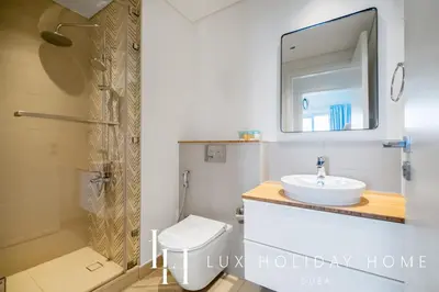 a bathroom with a sink and a shower and a toilet at LUX The Collective Dubai Hills Suite in Dubai