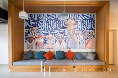 a couch with colorful pillows in front of a mural at LUX The Collective Dubai Hills Suite in Dubai