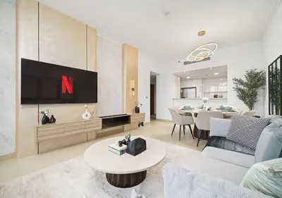 a living room with a tv on a wall at Royal Vista - Luxury 2BR Apartment with Burj Khalifa View at Burj Vista - Downtown in Dubai