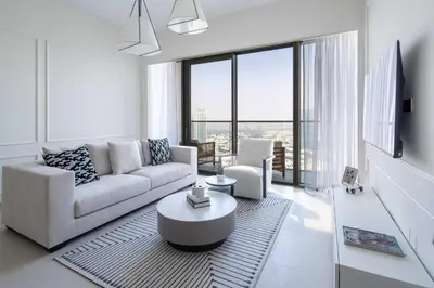 a white living room with a couch and a table at Frank Porter - Grande Signature Residences in Dubai