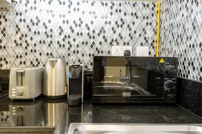 a kitchen counter with a microwave and a sink at KeyRock Luxury Apartment at Aykon Tower with Views in Dubai