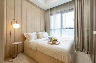 a bedroom with a bed with a table and a window at KeyRock Luxury Apartment at Aykon Tower with Views in Dubai