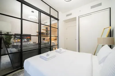a bedroom with a white bed and a large window at SettlerHomes - Idyllic Dubai Hills Stay Near Parkside in Dubai