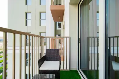 a balcony with a chair on a building at SettlerHomes - Idyllic Dubai Hills Stay Near Parkside in Dubai
