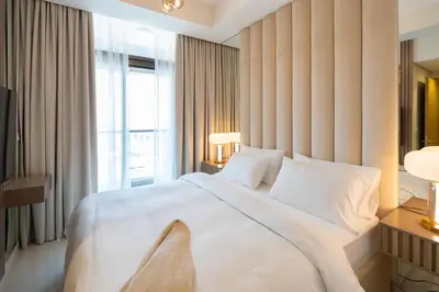 a bedroom with a large white bed and a window at Keyrock Living - Luxury Stay in Business Bay in Dubai