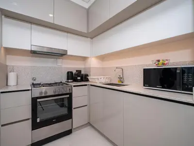 a kitchen with white cabinets and a microwave at Gorgeous Beachfront 2 Bed Retreat in Marina Vista in Dubai