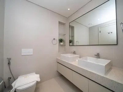 a white bathroom with two sinks and a mirror at Gorgeous Beachfront 2 Bed Retreat in Marina Vista in Dubai