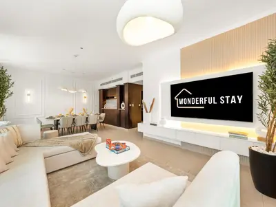 a living room with a tv on a wall at WonderfulStay at The Residences - Best Burj Khalifa & Fountain View - Brand New Luxury Apartments in Dubai