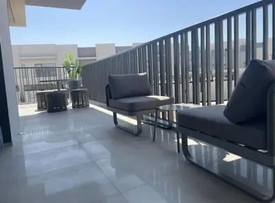 a balcony with a couch and chairs on a balcony at Brand New Designer 1-Bedroom Apartment With Free Parking in Dubai