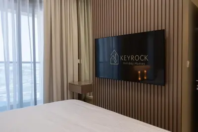 a bedroom with a tv on a wall at Keyrock Living - Dubai Oasis with Balcony Views in Dubai