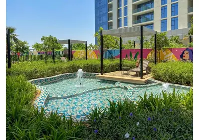 a small pool with a fountain in a park at Keyrock Living - Dubai Oasis with Balcony Views in Dubai