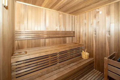 a wooden sauna with a wooden bench in it at Keyrock Living - Dubai Oasis with Balcony Views in Dubai