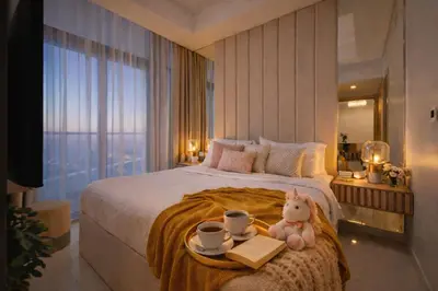 a bed with a tray with two cups and a teddy bear at Keyrock Stylish Apartment in Dubai with Pool and Gym in Dubai