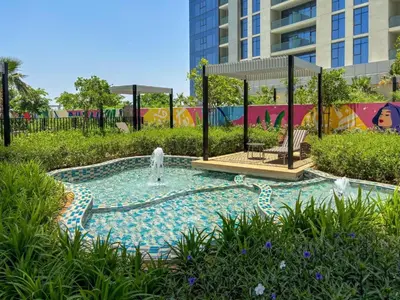 a swimming pool with a fountain in a park at Keyrock Stylish Apartment in Dubai with Pool and Gym in Dubai