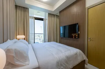 a bedroom with a white bed and a television at KeyRock Elegant Aykon Apartment with City Views in Dubai