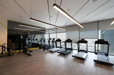 a gym with a row of treadmills and machines at KeyRock Elegant Aykon Apartment with City Views in Dubai