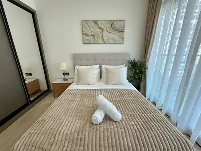 a bedroom with a large bed with a white headboard at Cozy 1br Apartment In Jvc Free Parking & Pool in Dubai