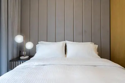 a bed with white sheets and pillows at Keyrock Living - Luxe 2BR in Business Bay in Dubai