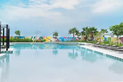 a large swimming pool with chairs and a building at Keyrock Living - Luxe 2BR in Business Bay in Dubai