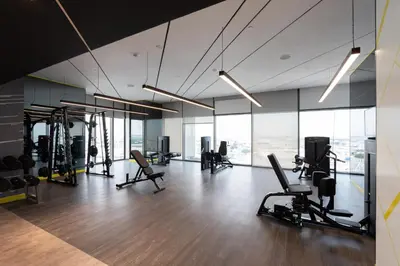 a gym with treadmills and chairs in a room with windows at Keyrock Living - Luxe 2BR in Business Bay in Dubai