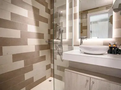 a bathroom with a sink and a glass shower at Seafront Escape Infinity Pool & Private Beach in Dubai