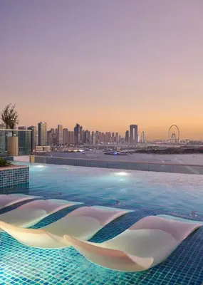 a swimming pool with a city skyline in the background at Seafront Escape Infinity Pool & Private Beach in Dubai