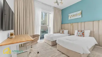 a hotel room with two beds and a desk at Sea-view 2BD apt with private beach in La Vie in Dubai