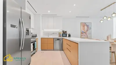 a kitchen with a stainless steel refrigerator and wooden cabinets at Sea-view 2BD apt with private beach in La Vie in Dubai