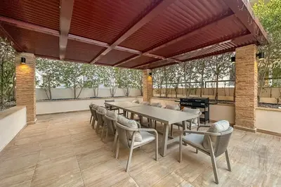 a patio with a table and chairs and a grill at Pool View 1BR in Dubai Free Parking Gym Near Parks and Golf in Dubai
