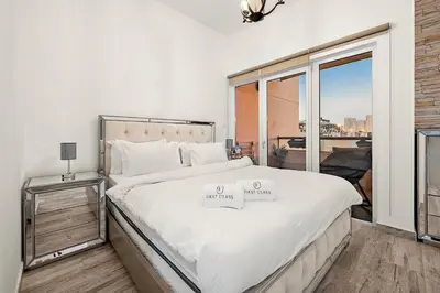 a bedroom with a large bed and a large window at Pool View 1BR in Dubai Free Parking Gym Near Parks and Golf in Dubai