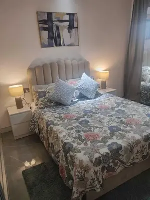 a bedroom with a bed with a floral bedspread and two lamps at Ahlan Premium Spacious Luxury Furnished 2 Bedroom Apartment Marina Beach JBR for Families and Groups in Dubai