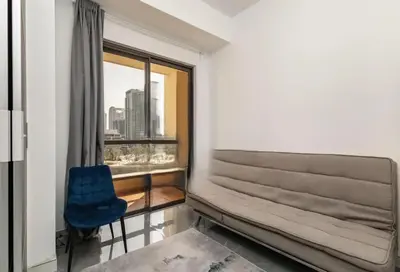 a room with a window and a blue chair at Ahlan Premium Spacious Luxury Furnished 2 Bedroom Apartment Marina Beach JBR for Families and Groups in Dubai